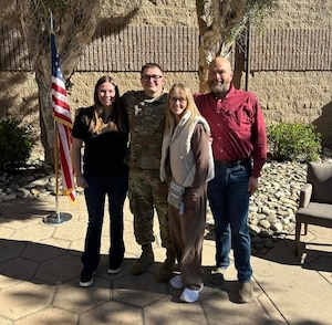 Hollie Carr, 576th Flight Test Squadron Key Support Liaison (left) and Maj. Tyler Carr, 576th FLTS assistant director of operations pose for a photo with family members outside.