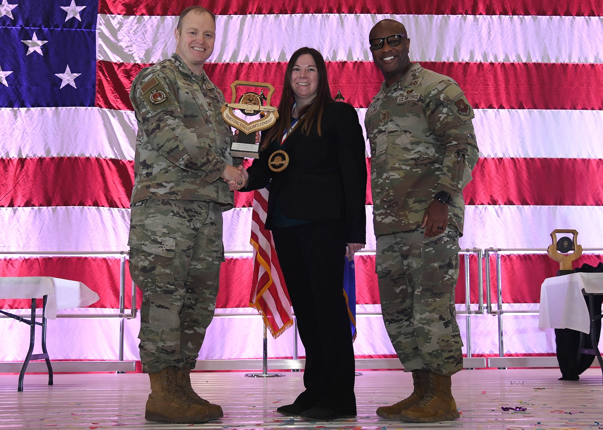 Col. Michael Power, 377th Air Base Wing and installation commander (left), Chief Master Sgt. Antonio Cooper, 377th ABW command chief (right), and Hollie Carr, 576th Flight Test Squadron Key Support Liaison (center), pose for an award photo during the 377th ABW Annual Awards ceremony at Kirtland Air Force Base