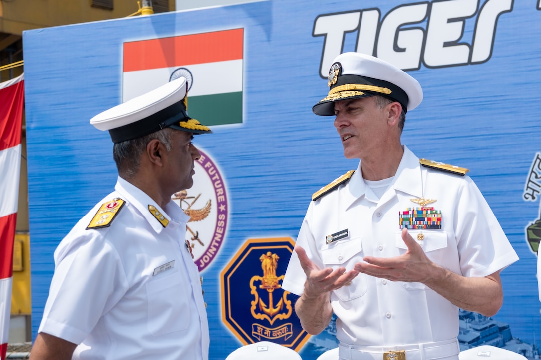 VISAKHAPATNAM, Andhra Pradesh, India (April 1, 2025) - Rear Adm. Greg Newkirk, Commander, Task Force (CTF) 70, speaks with Indian Navy (IN) Rear Adm. Susheel Menon, Flag Officer Commanding Eastern Fleet (FOCEF), on the flight deck aboard the IN amphibious transport dock INS Jalashwa (L41) during the opening ceremony of Exercise Tiger Triumph 2025, at the Naval Dockyard, Visakhapatnam, Andhra Pradesh, India, April 1. Tiger Triumph is a joint and combined U.S.-India exercise focused on humanitarian assistance and disaster relief readiness and interoperability. Tiger Triumph enables U.S. and Indian armed forces to improve interoperability and bilateral, joint, and service readiness in the Indian Ocean region and beyond to support a free and open Indo-Pacific. (U.S. Navy photo by Mass Communication Specialist 1st Class Caroline H. Lui)