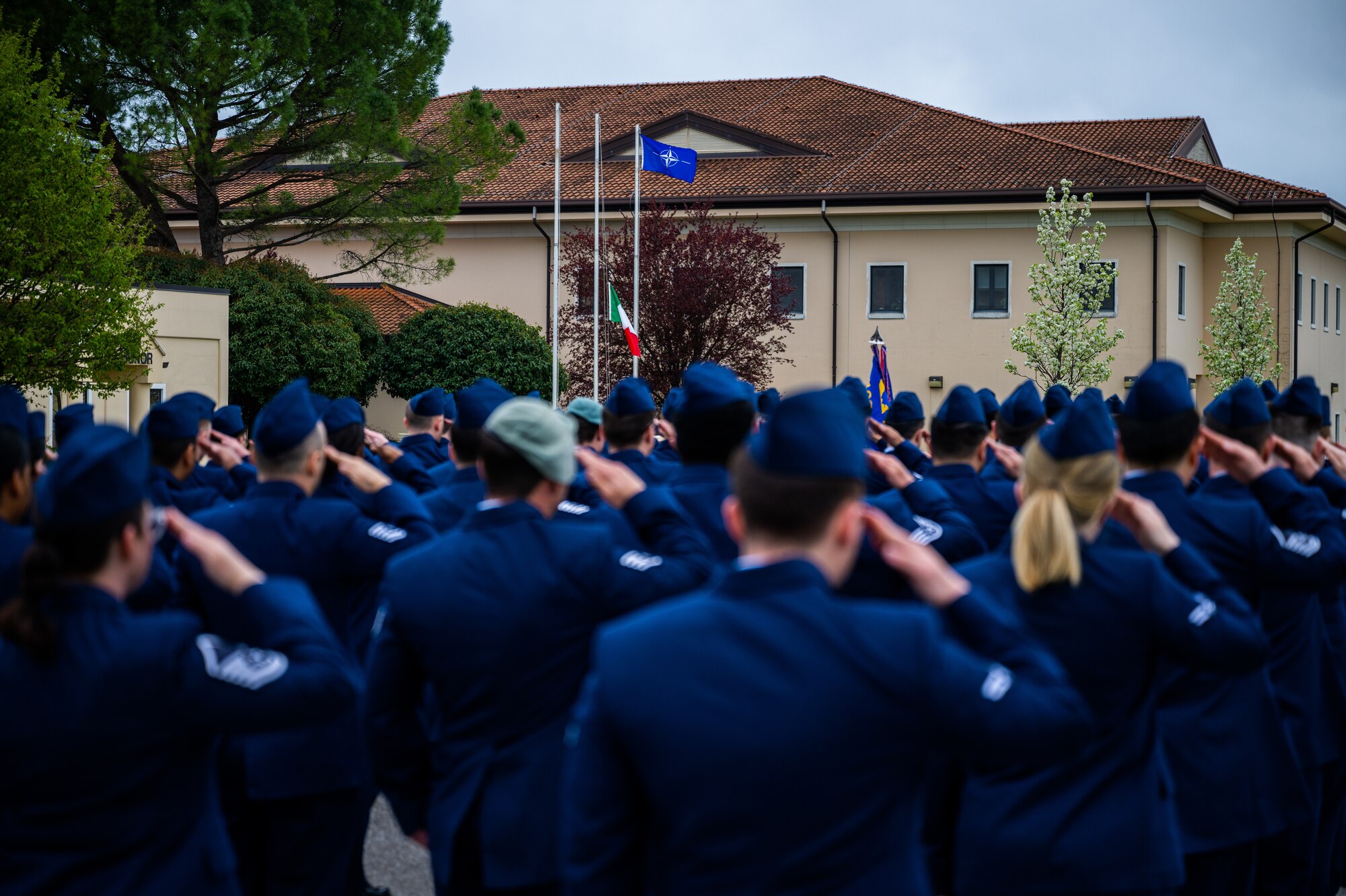 U.S. Air Force Airmen from the 31st Operations Support Squadron salute the Italian flag during retreat.
