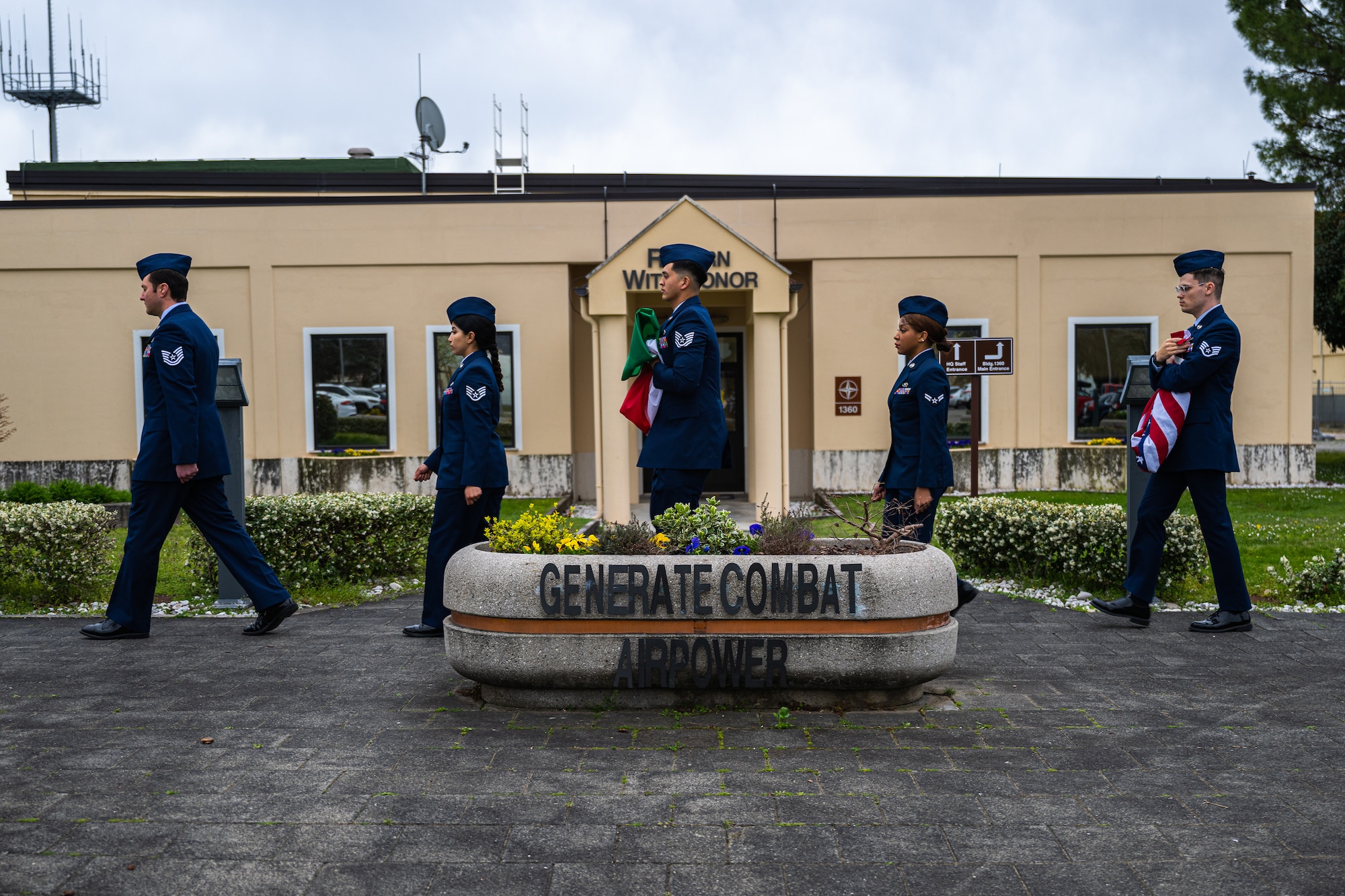 A detail of U.S. Air Force Airmen from the 31st Operations Support Squadron carry the U.S. and Italian flags after retreat.