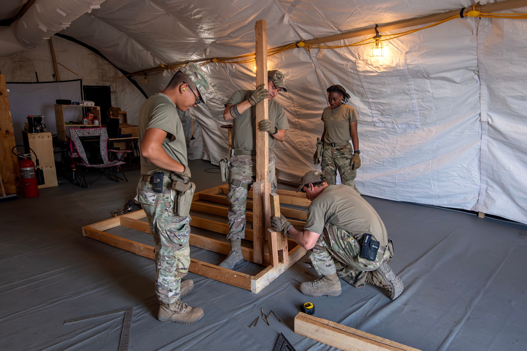Members of the 475th Civil Engineer Flight at Camp Simba, Manda Bay, Kenya, collaborate on ongoing installation improvement projects on Jan. 15, 2025. The joint-service engineer force at Camp Simba has been integral to the plans and preparations ahead of the Department of Defense and Department of State expansion of the strategic operating location, including 294,000 square feet of airfield construction and increased fuel storage capacity. Enduring infrastructure is vital to enhancing interoperability and will enable Kenya's continued growth as a strategic military partner, with the capacity to maintain security in the region against threats like Al-Shabaab. (U.S. Air Force photo by Tech. Sgt. Jana Somero)