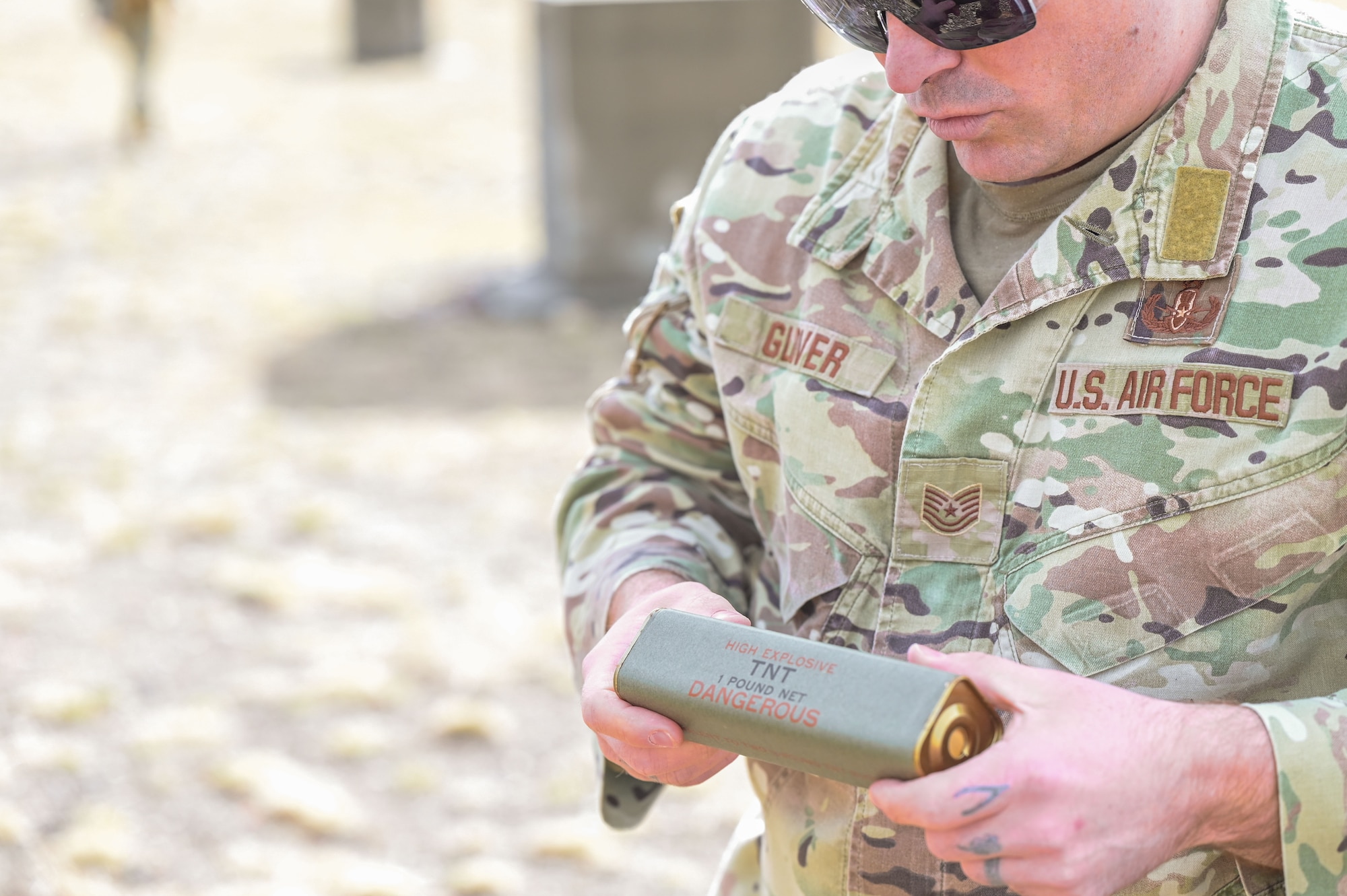 Airman holds a block of trinitrotoluene.