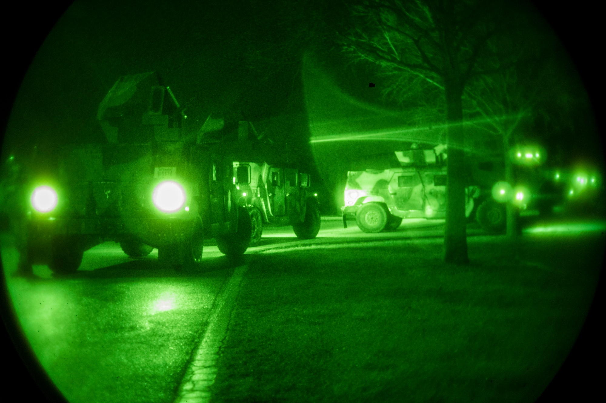 A line of armored vehicles at night
