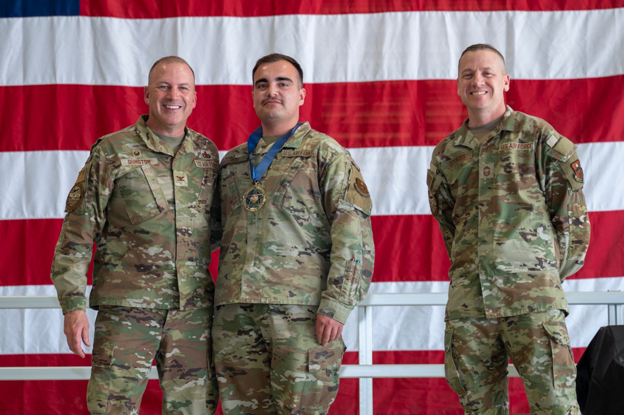 U.S. Air Force Senior Airman Isaac Smith, center, accepts the gold category annual Quality Assurance Excellence Award from U.S. Air Force Col. Chris Dunston, 49th Maintenance Group commander, left, and U.S. Air Force Chief Master Sgt. Andrew Stokes, 49th MXG superintendent, at Holloman Air Force Base, New Mexico, March 28, 2025. The Annual Quality Assurance Excellence Award is a significant recognition for maintainers who consistently demonstrate exceptional performance and attention to detail, with achieving a 100% pass rate over an entire year being a remarkable accomplishment in the critical and demanding field of aircraft maintenance. (U.S. Air Force photo by Senior Airman Michelle Ferrari)
