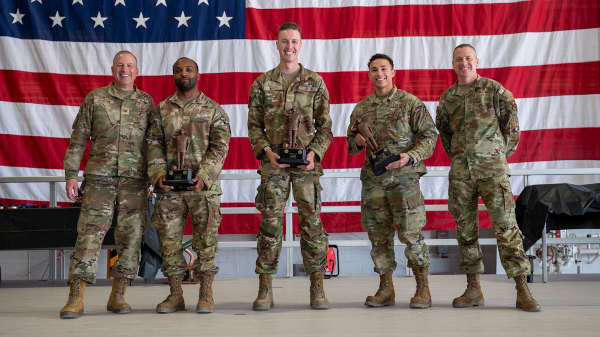U.S. Air Force Airmen of the 49th Maintenance Group accept the Load Crew of the Year Award from U.S. Air Force Col. Chris Dunston, 49th Maintenance Group commander and U.S. Air Force Chief Master Sgt. Andrew Stokes, 49th MXG superintendent, at Holloman Air Force Base, New Mexico, March 28, 2025. The Load Crew of the Year Award recognizes the top-performing and outstandings weapons load crews. (U.S. Air Force photo by Senior Airman Michelle Ferrari)
