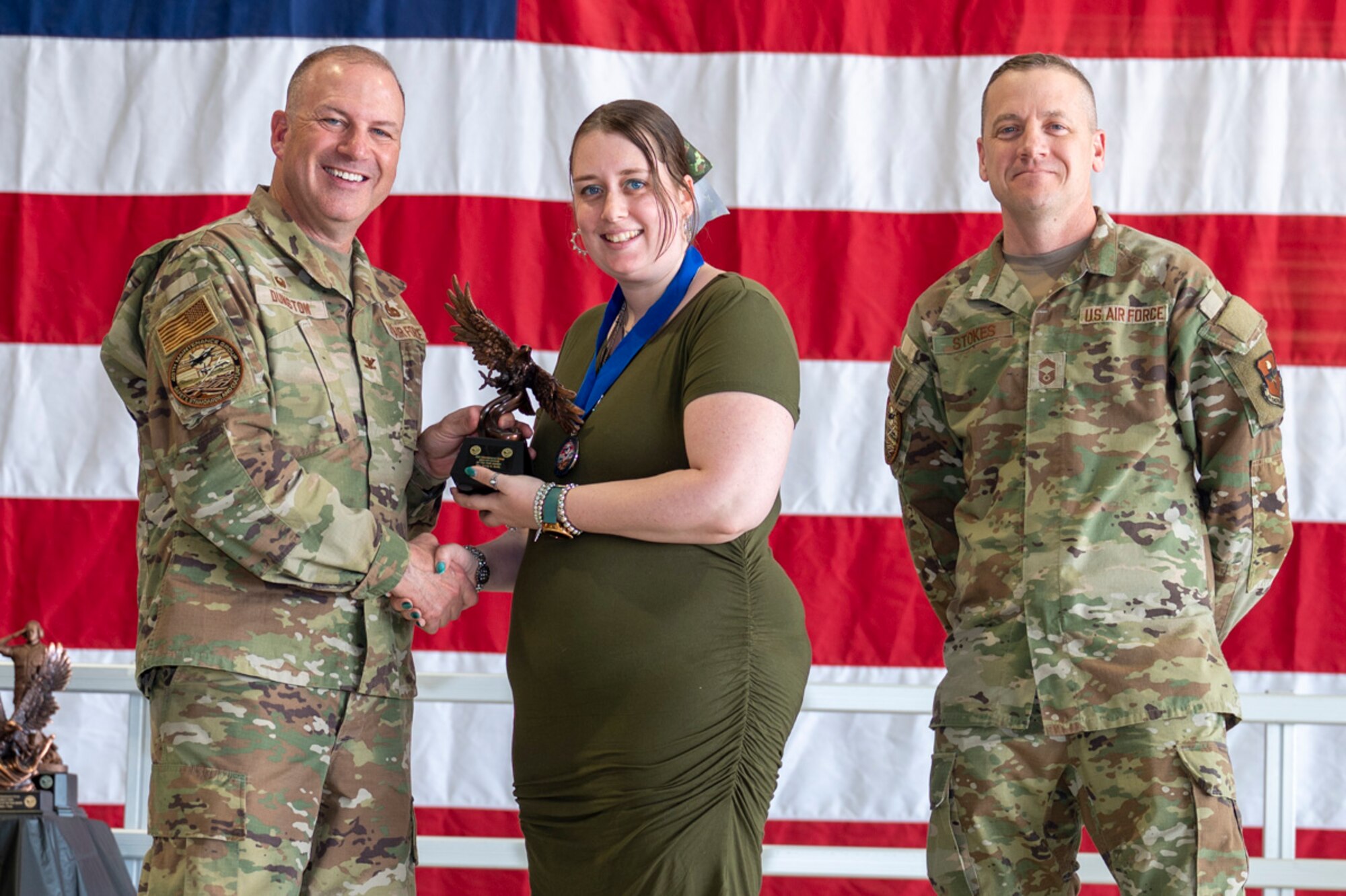 Ashley Wolfe, center, accepts the Key Spouse of the Year Award from U.S. Air Force Col. Chris Dunston, 49th Maintenance Group commander and U.S. Air Force Chief Master Sgt. Andrew Stokes, 49th MXG superintendent, at Holloman Air Force Base, New Mexico, March 28, 2025. The Key Spouse of the Year Award recognizes a volunteer military spouse who has demonstrated exceptional service to their unit’s families. (U.S. Air Force photo by Senior Airman Michelle Ferrari)