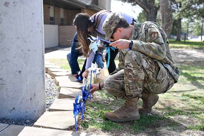 People place pinwheels into the ground