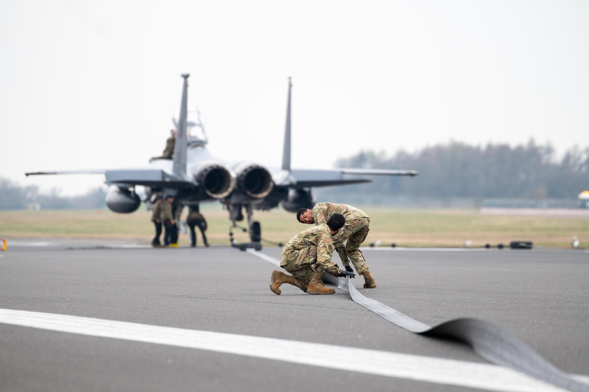 Airmen inspect the tape of a Mobile Aircraft Arresting System