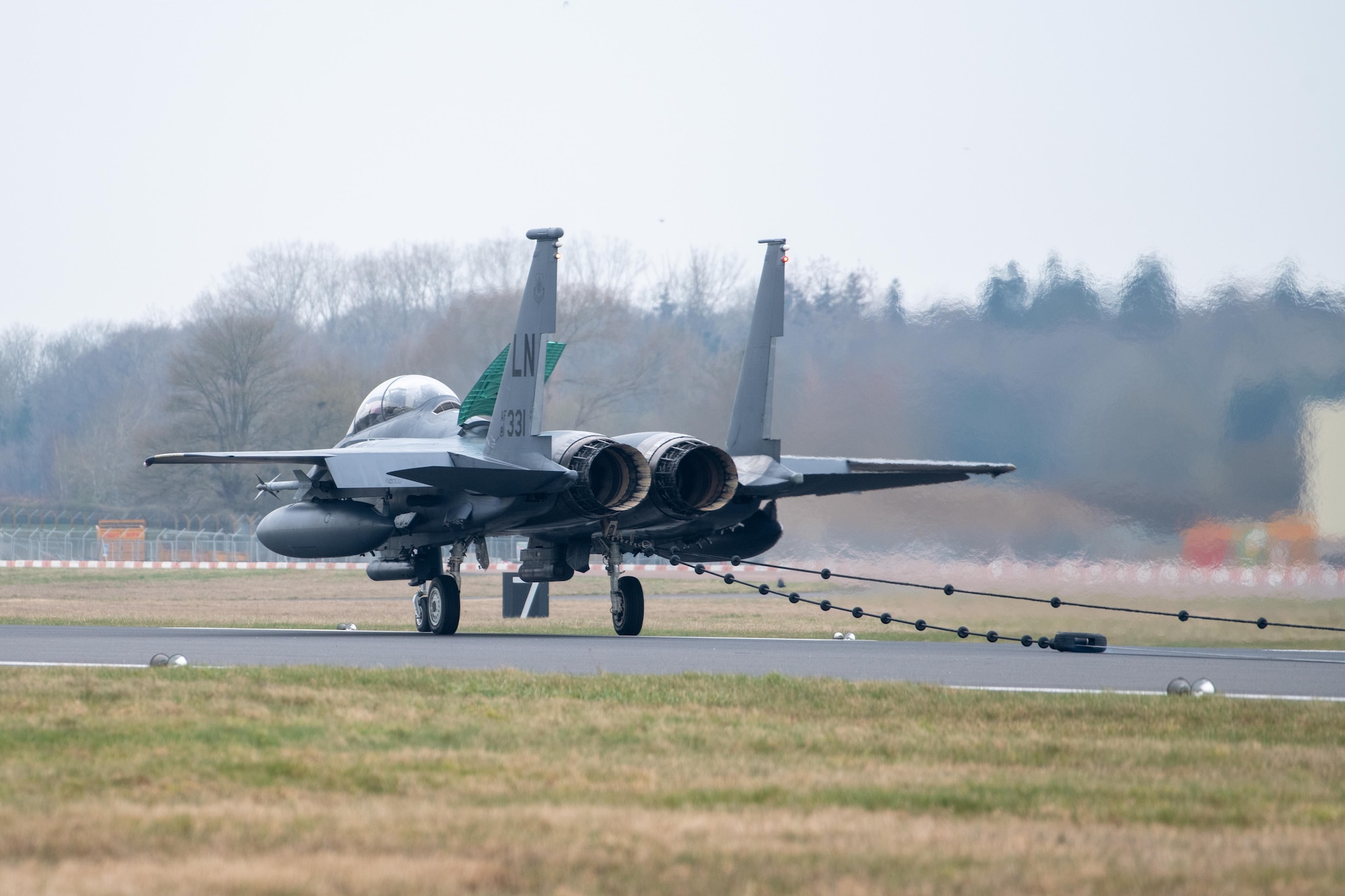 A F-15E Strike Eagle sits on a runway after testing a Mobile Aircraft Arresting System