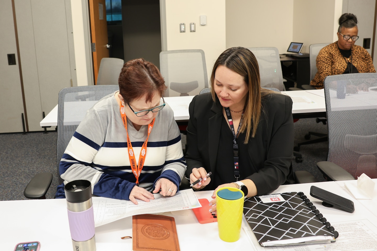 Two women review a document.