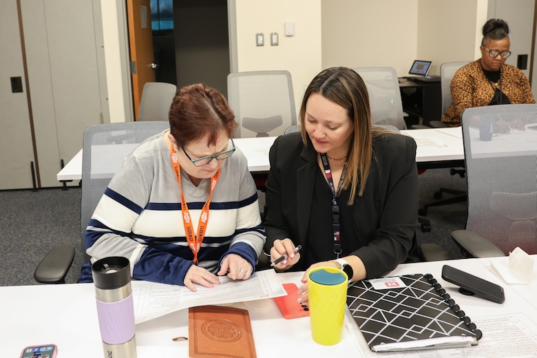 Two women review a document.