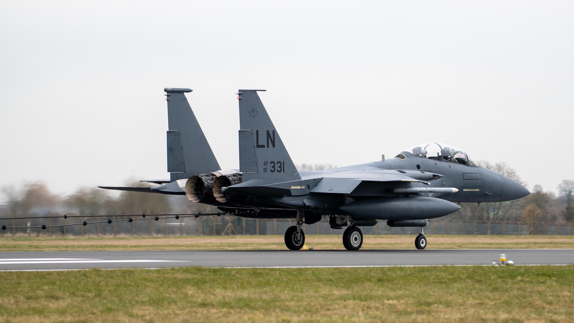 A F-15E Strike Eagle sits on a runway after testing a Mobile Aircraft Arresting System