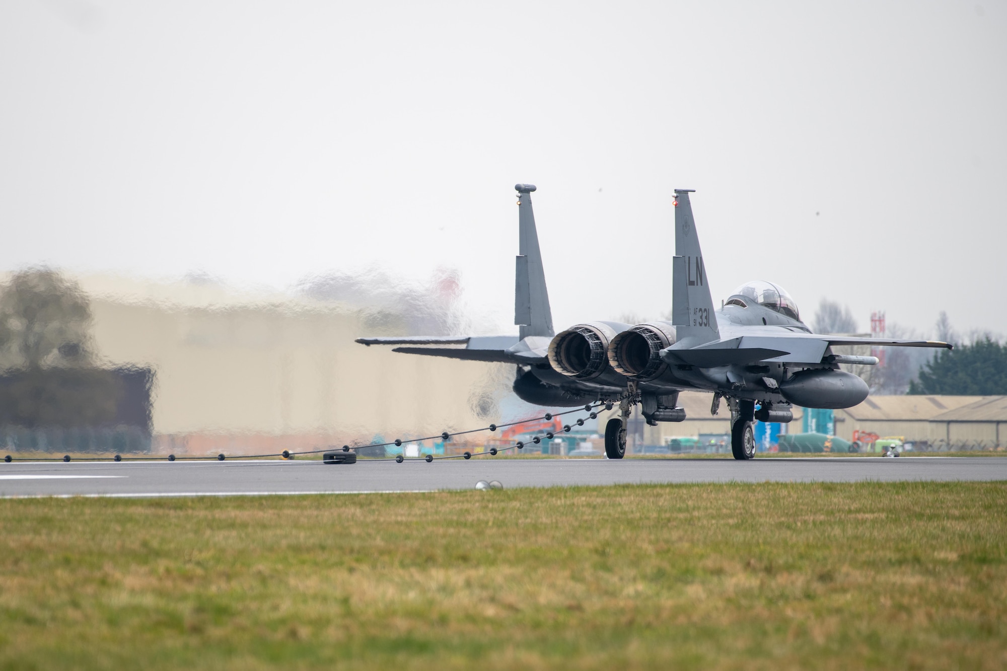 A F-15E Strike Eagle sits on a runway after testing a Mobile Aircraft Arresting System