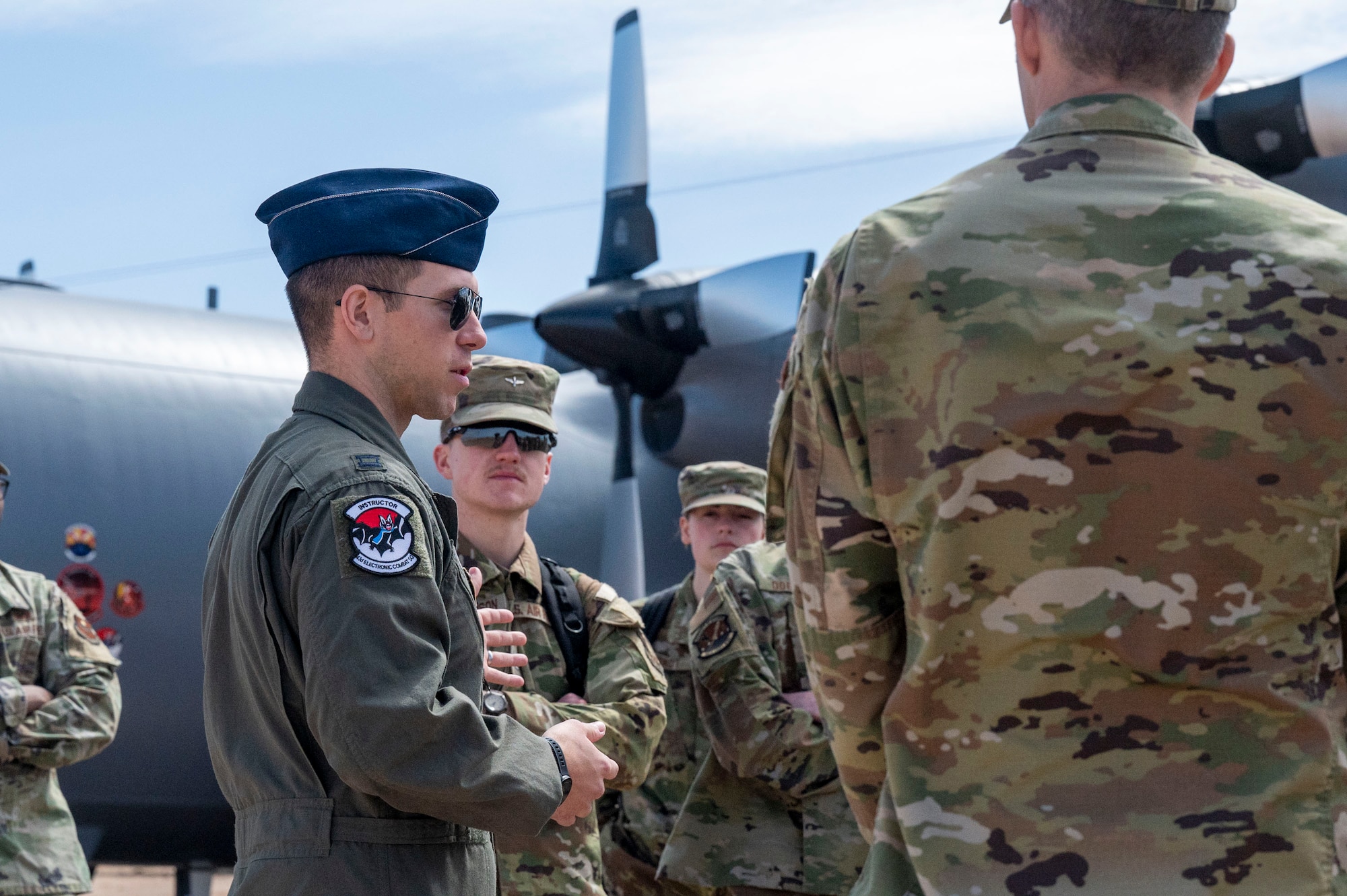 U.S. Air Force Capt. Joseph Ouellet, 43rd Electronic Combat Squadron, mission development officer in charge, briefs University of Wyoming U.S. Air Force Reserve Officers Training Course cadets during a tour at Davis-Monthan Air Force Base, Arizona, April 1, 2025. The EC-130H Compass Call is a modified C-130 Hercules aircraft used by the Air Force for electronic warfare, disrupting enemy communications and command and control systems. (U.S. Air Force photo by Airman Samantha Melecio)