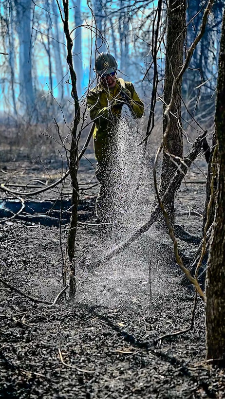 Firefighter puts out flames with a hose