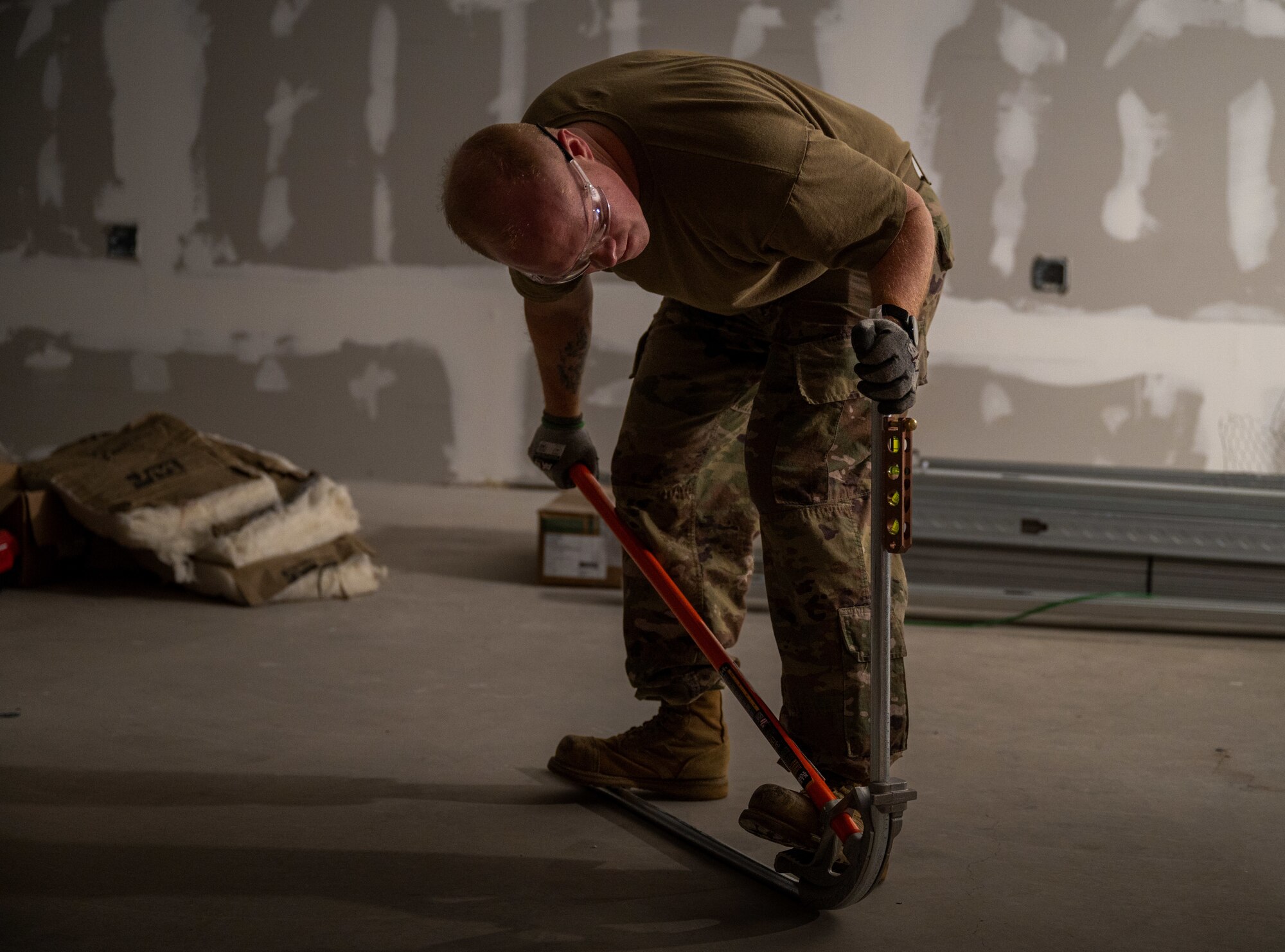 U.S Air Force Tech. Sgt. Brandon Gilmore, electrical journeyman, 445th Civil Engineer Squadron, bends a pipe while using a level during a deployment for training at Patrick Space Force Base, Florida, March 5, 2025. The deployment for training included Airman from the 445th CES from Wright-Patterson Air Force Base remodeling a joint warehouse space on PSFB to convert it into office space for the Requirements and Optimization office of the 45th Civil Engineer Squadron. (U.S. Space Force photo by Senior Airman Spencer Contreras)