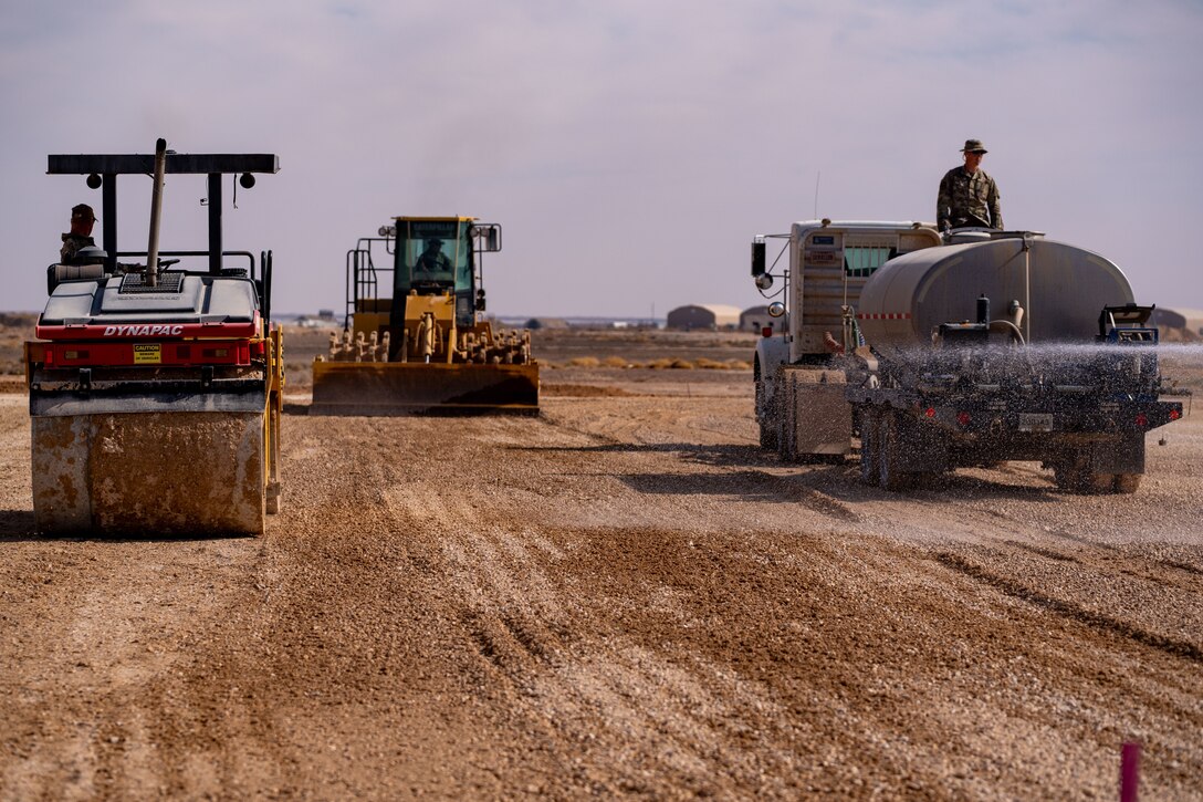 Air Force construction vehicles prep a subgrade for asphalt installation in the U.S. Central Command area of responsibility.