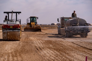 Air Force construction vehicles prep a subgrade for asphalt installation in the U.S. Central Command area of responsibility.