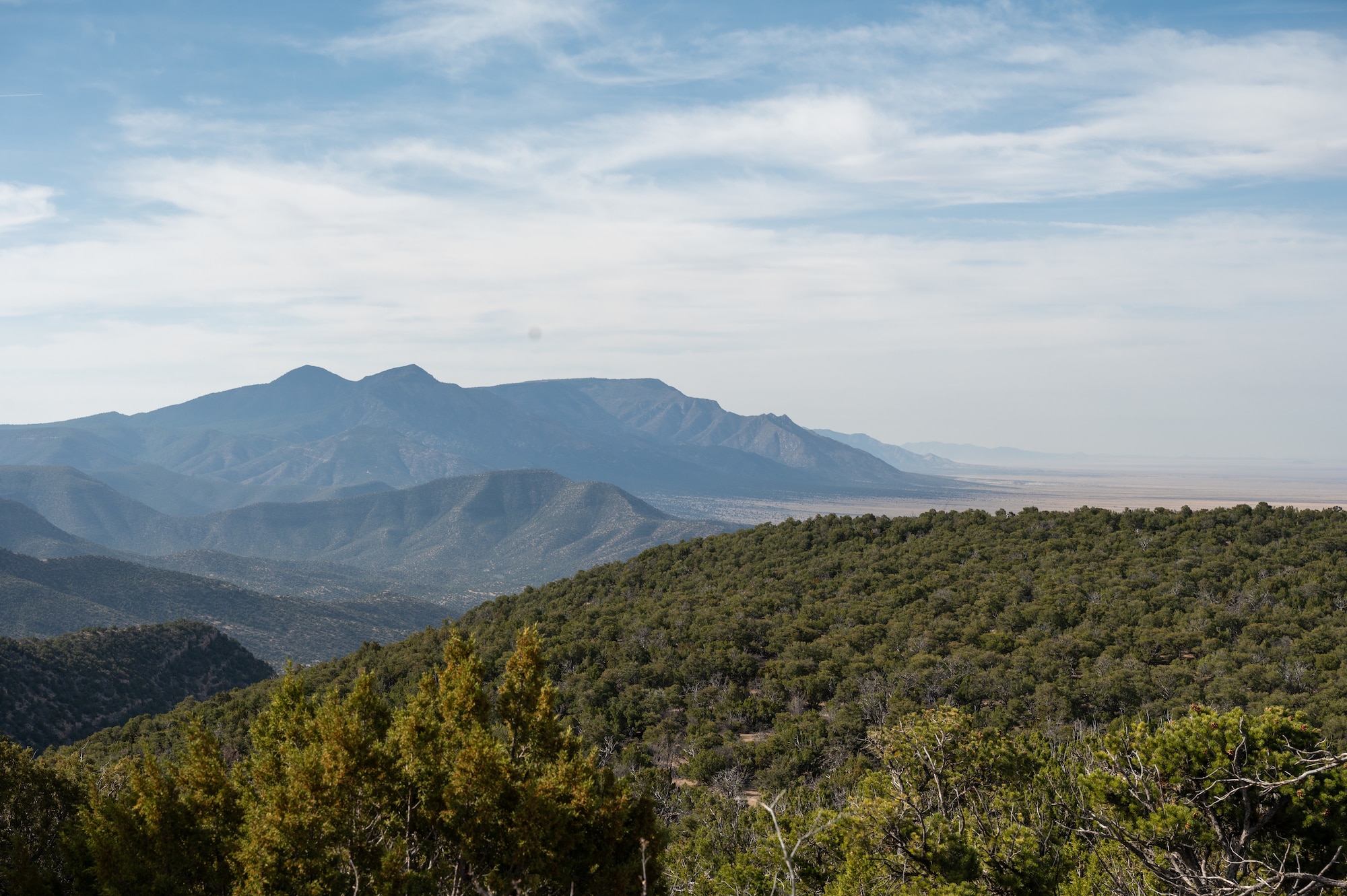A view of the withdrawn area of Kirtland Air Force Base, N.M., showcasing the rugged terrain and diverse ecosystem that the installation is working to protect. Kirtland AFB has deployed advanced wildfire detection sensors in this region to enhance fire prevention efforts and safeguard natural resources. These conservation initiatives align with the base's commitment to environmental stewardship and mission readiness. (U.S. Air Force photo by Airman 1st Class Donnell Schroeter)