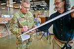 A military officer in uniform signs a proclamation
