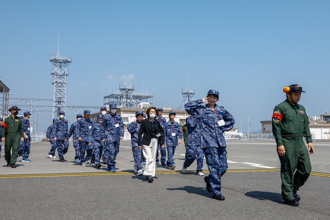 Japanese nationals walk to a Japan Maritime Self-Defense Force ShinMaywa US-2 aircraft with Air Rescue Squadron 71 (ARS-71), Fleet Air Wing 31, during an aerial tour at Marine Corps Air Station Iwakuni, Japan, March. 22, 2025. The JMSDF invited Japanese nationals interested in joining the service to fly in a US-2 as part of the Japan Self-Defense Force U-32 program, which strives to recruit new service members under the age of 32. (U.S. Marine Corps photo by Lance Cpl. David Getz)