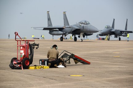 A U.S. Air Force Airman assigned to the 77th Expeditionary Fighter Generation Squadron works on the flightline as a Republic of Singapore Air Force F-15SG taxis to the runway during exercise Cope Tiger 25 at Korat Royal Thai Air Base, Thailand, Mar. 27, 2025.