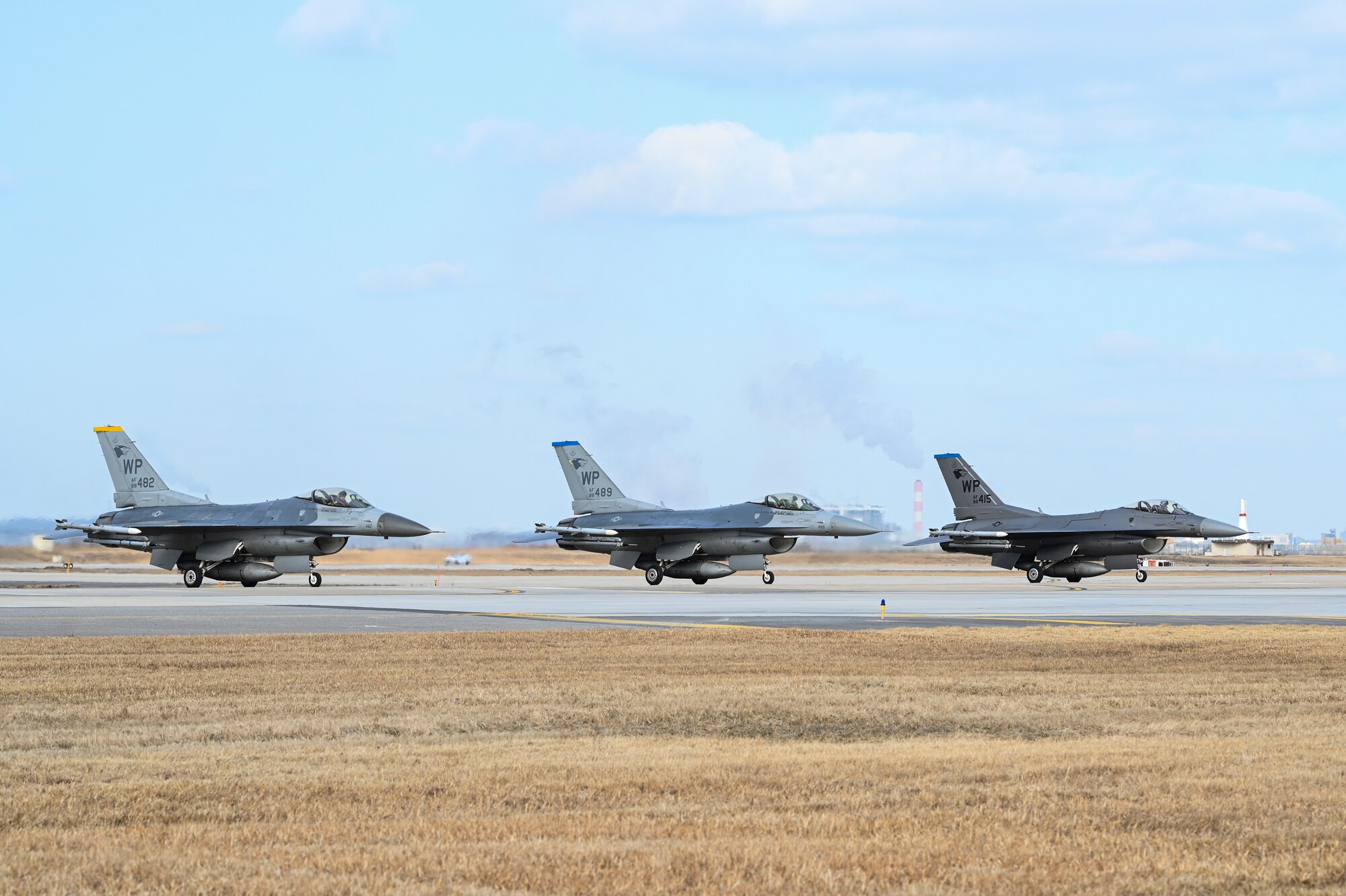 Three F-16 Fighting Falcon aircraft assigned to the 8th Fighter Wing are parked on the flight line during an operational surge.