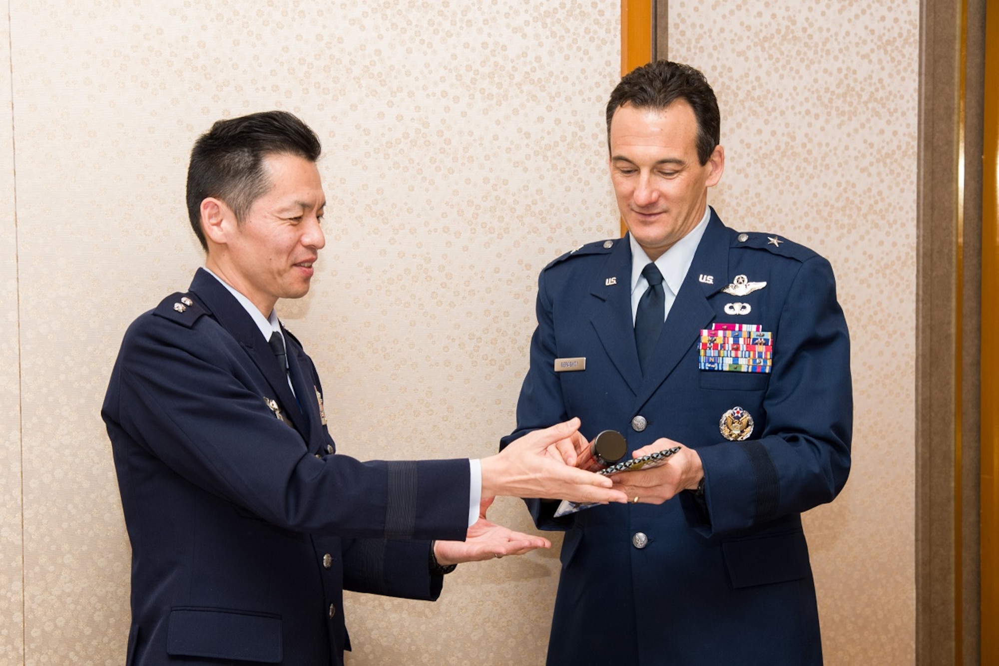 Maj. Gen. Takanari Ogawa, (left), Deputy Director General (Import Equipment and Aircraft) for the Japan Air Force Defense Force's Acquisition, Technology, & Logistics Agency, presents a thermos painted with Mt. Fuji decorations, to Brig. Gen. Jeffrey Geraghty, the Director of the U.S. Air Force Security Assistance and Cooperation Directorate, as well as Director of International Affairs for the Air Force Materiel Command. (Courtesy photo)