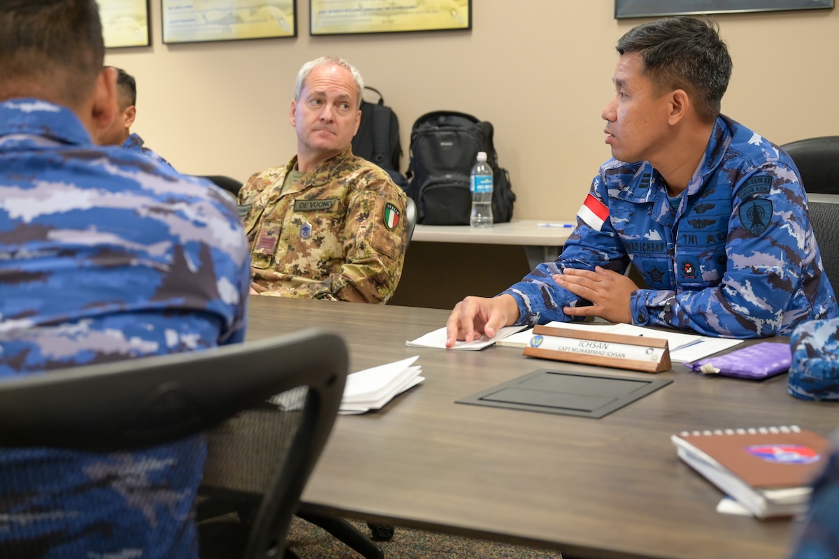 A photo of foreign air battle managers talking.