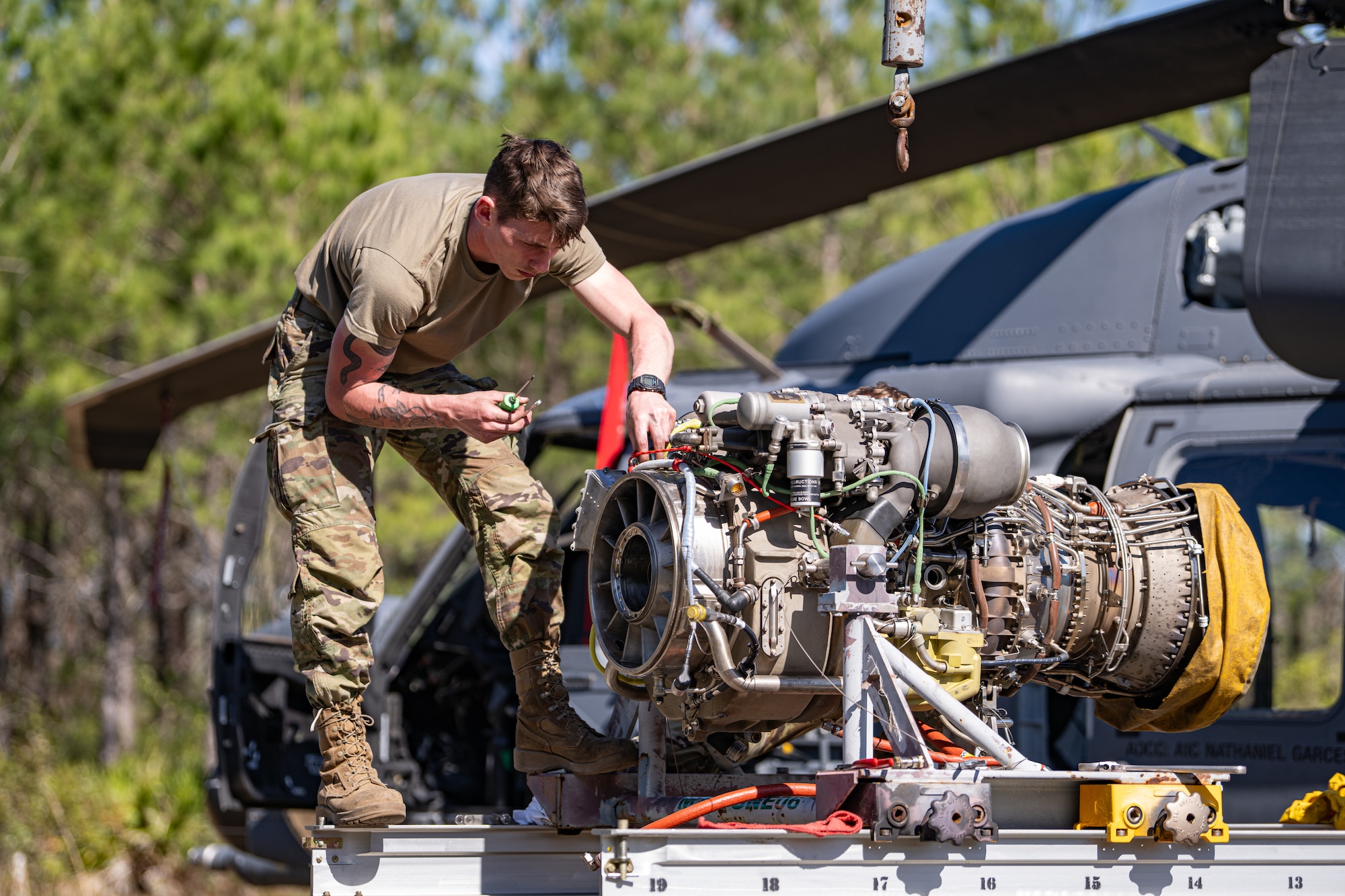An Airman is fixing an engine.
