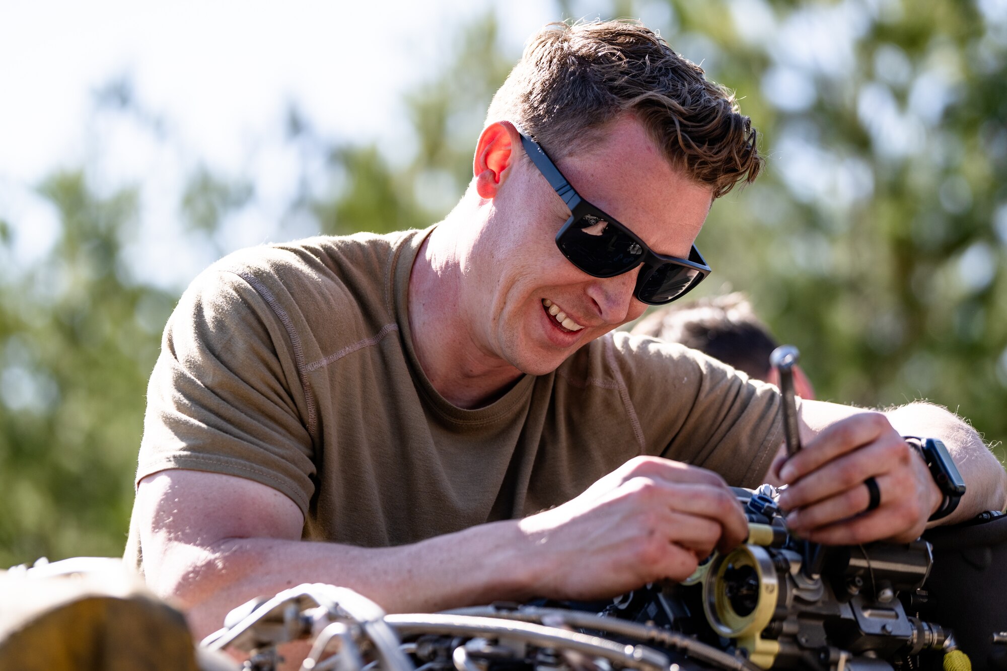 An Airman is fixing an engine.