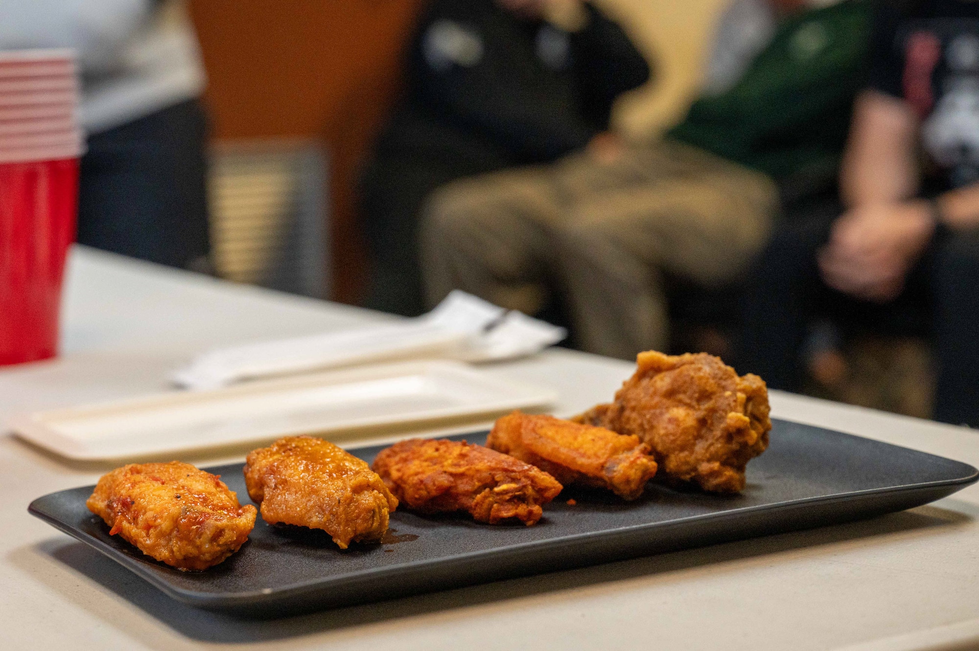 Five chicken wings sit at a table