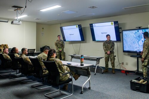 Defenders assigned to the 374 Security Forces Squadron deliver a briefing to simulated commanders.