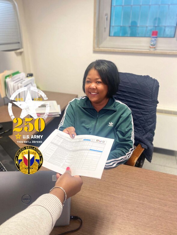 Charis Ford presents an updated command supply disciple program checklist to one of her coworkers at her office on Caserma Ederle in Vicenza, Italy, April 3. Ford, who previously served in the Air Force, is responsible for managing CSDP for Logistics Readiness Center Italy. She was active-duty Air Force for almost 10 years, and now she’s an Army civilian employee for nearly 10 more. “Happy 250th birthday, U.S. Army!” Ford said. (U.S. Army courtesy photo)