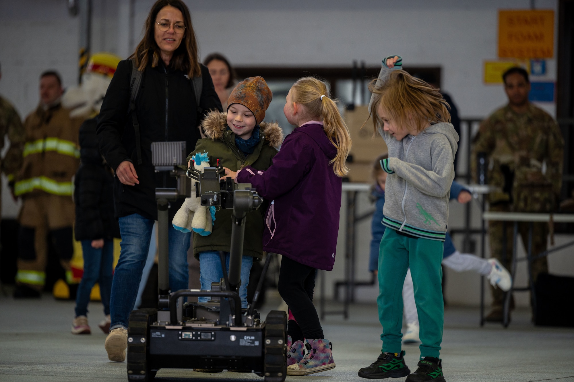 students grab a toy from a robot arm