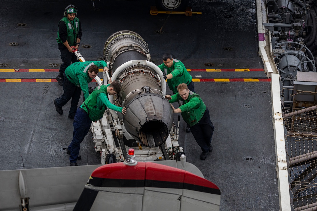 Sailors assigned to the "Ragin' Bulls" of Strike Fighter Squadron (VFA) 37, move an F/A-18E Super Hornet engine across the flight deck of the world's largest aircraft carrier, USS Gerald R. Ford (CVN 78), March 31, 2025.