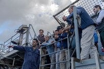 Fire Controlman 1st Class Matthew Perez (left), assigned to combat systems department aboard the world's largest aircraft carrier, USS Gerald R. Ford (CVN 78), explains a weapons system to distinguished visitors (DV), March 29, 2025.