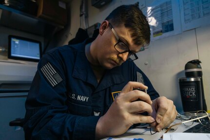 Hospital Corpsman 2nd Class Connor Daniels, assigned to medical department aboard the world's largest aircraft carrier, USS Gerald R. Ford (CVN 78), tightens a screw on an eyeglass frame while making of a pair of eyeglasses in the eyeglass fabrication room, March 29, 2025.