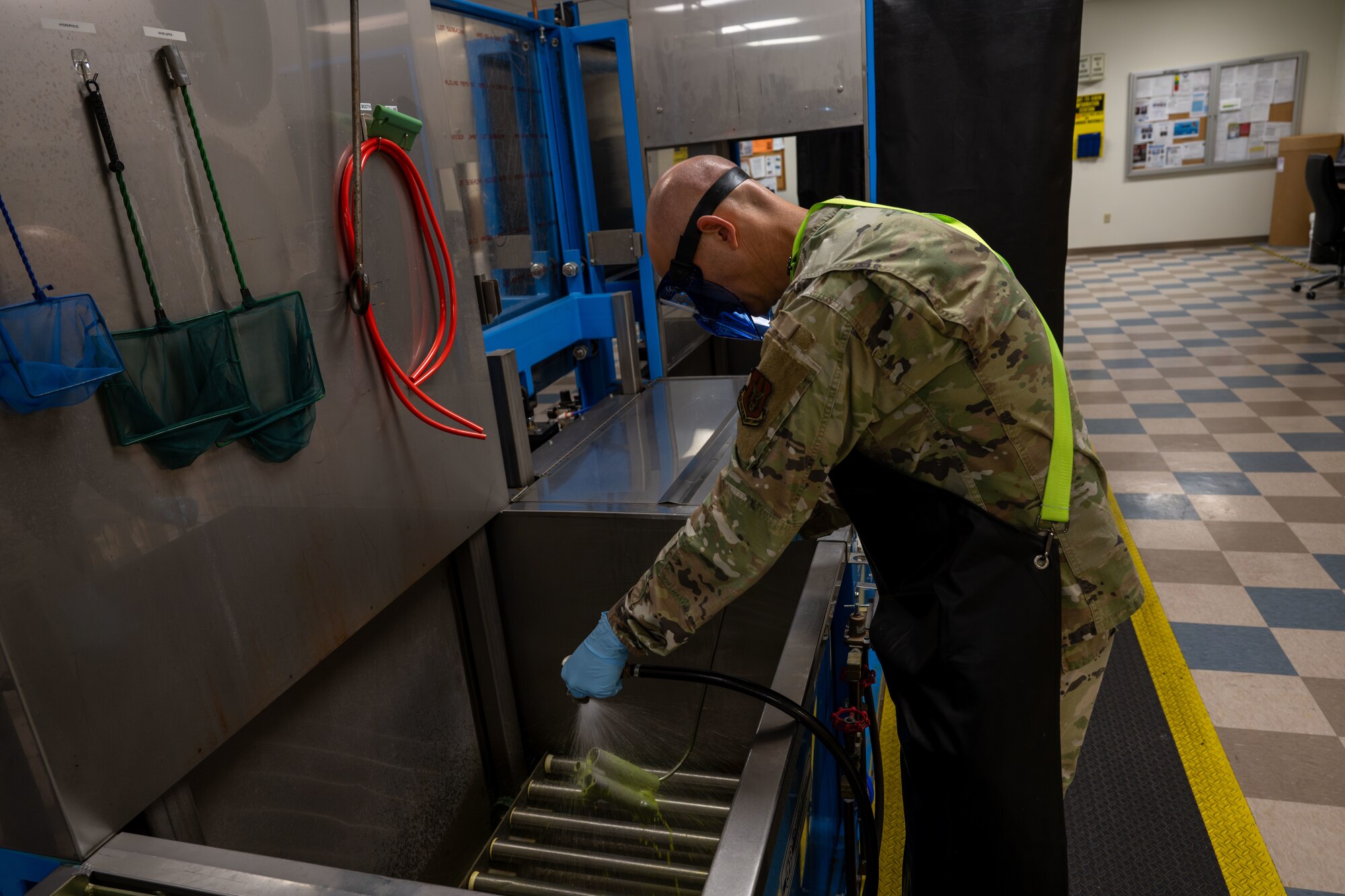 Master Sgt. Jason Barker, 931st Maintenance Squadron nondestructive inspection section chief, rinses penetrating fluid off a KC-135 Stratotanker part April 1, 2025, at McConnell Air Force Base, Kansas. NDI specialists use the penetrant liquid inspection method to detect defects in small aircraft parts, ensuring the parts’ structural integrity and ultimately protecting the lives of pilots and air crew. (U.S. Air Force photo by Airman 1st Class Paula Arce)