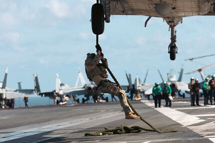 Sailors assigned to Explosive Ordnance Disposal Mobile Unit (EODMU) 12 fast rope from an MH-60S Sea Hawk, attached to the "Tridents" of Helicopter Sea Combat Squadron (HSC) 9, onto the flight deck of the world's largest aircraft carrier, USS Gerald R. Ford (CVN 78), March 28, 2025.