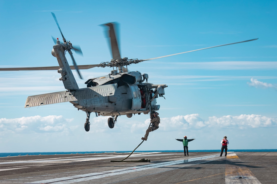 Sailors assigned to Explosive Ordnance Disposal Mobile Unit (EODMU) 12 fast rope from an MH-60S Sea Hawk, attached to the "Tridents" of Helicopter Sea Combat Squadron (HSC) 9, onto the flight deck of the world's largest aircraft carrier, USS Gerald R. Ford (CVN 78), March 28, 2025.