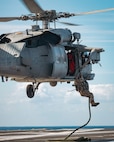 Sailors assigned to Explosive Ordnance Disposal Mobile Unit (EODMU) 12 fast rope from an MH-60S Sea Hawk, attached to the "Tridents" of Helicopter Sea Combat Squadron (HSC) 9, onto the flight deck of the world's largest aircraft carrier, USS Gerald R. Ford (CVN 78), March 28, 2025.