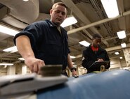 Aviation Ordnanceman 3rd Class Dakota Silbaugh (left) and Aviation Ordananceman Airman Jordan Gartrell, both assigned to weapons department aboard the world’s largest aircraft carrier, USS Gerald R. Ford (CVN 78), inspect training ammo in the weapons transfer area, March 27, 2025.