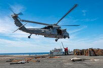 Sailors assigned to weapons department hook cargo to an MH-60S Sea Hawk, attached to the "Tridents" of Helicopter Sea Combat Squadron (HSC) 9, during a vertical replenishment (VERTREP) on the flight deck of the world's largest aircraft carrier, USS Gerald R. Ford (CVN 78), March 27, 2025.