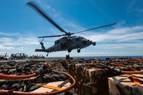 Sailors assigned to weapons department aboard the world's largest aircraft carrier, USS Gerald R. Ford (CVN 78), hook cargo to an MH-60S Sea Hawk, attached to the "Tridents" of Helicopter Sea Combat Squadron (HSC) 9, during a vertical replenishment (VERTREP) on the flight deck, March 27, 2025.