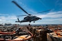Sailors assigned to weapons department aboard the world's largest aircraft carrier, USS Gerald R. Ford (CVN 78), hook cargo to an MH-60S Sea Hawk, attached to the "Tridents" of Helicopter Sea Combat Squadron (HSC) 9, during a vertical replenishment (VERTREP) on the flight deck, March 27, 2025.