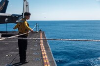 Aviation Boatswain’s Mate (Handling) 3rd Class McKenzie Cook, assigned to air department aboard the world's largest aircraft carrier, USS Gerald R. Ford (CVN 78), stands by to transport a pallet on the flight deck during a vertical replenishment (VERTREP), March 27, 2025.