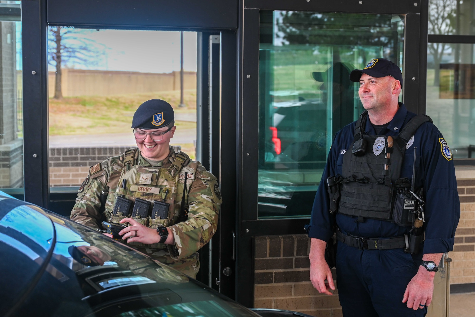 Airman 1st Class Macy Gerry, 22nd Security Forces Squadron entry controller, and Officer Joseph Holzman, 22nd Security Forces Squadron supervisory police officer, scan IDs while working together at the main gate March 31, 2025, at McConnell Air Force Base, Kansas. The Department of the Air Force (DAF) officers work alongside active-duty U.S. Air Force security forces members to keep the base safe. (U.S. Air Force photo by Senior Airman William Lunn)