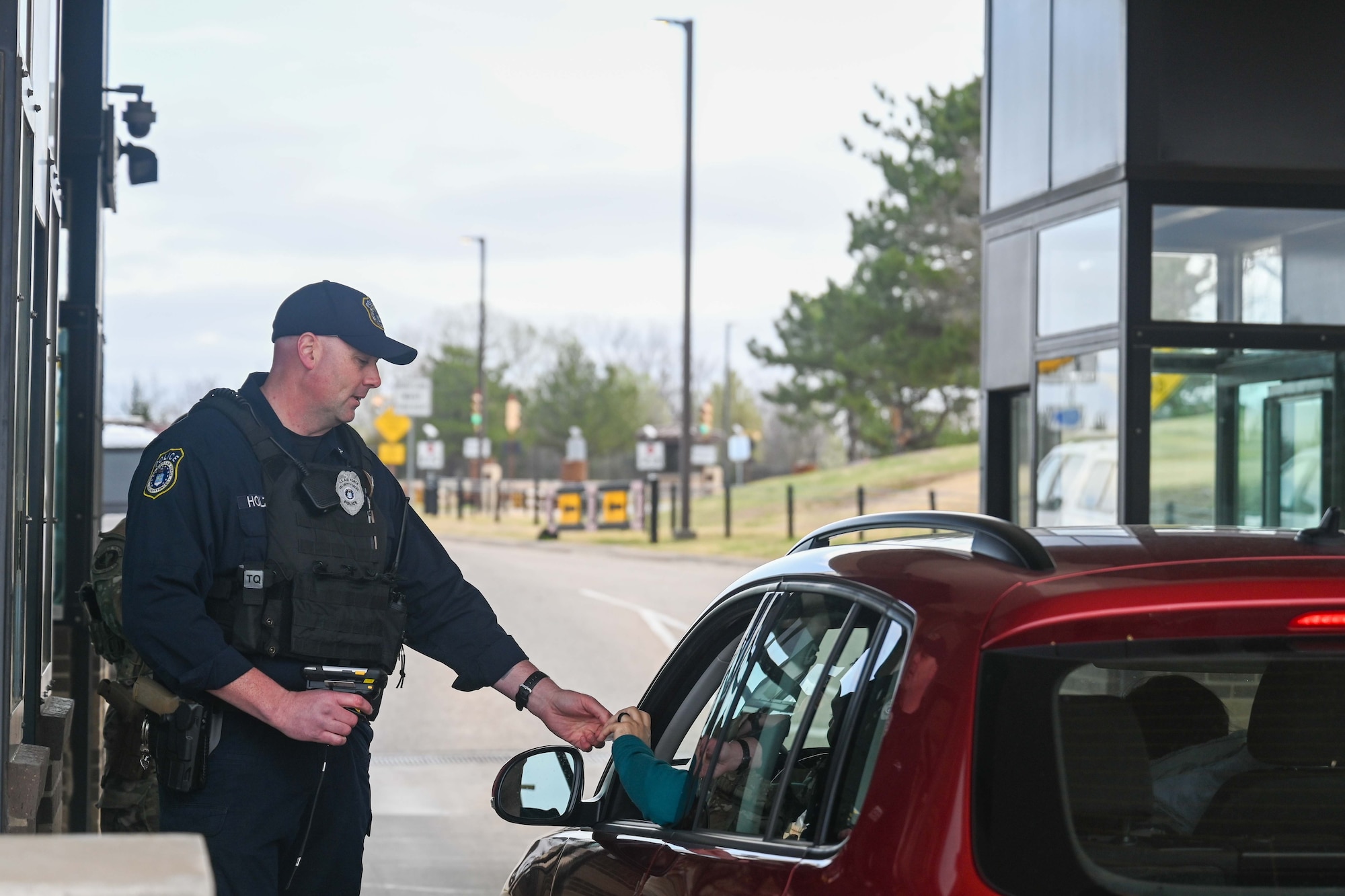 Officer Joseph Holzman, 22nd Security Forces Squadron supervisory police officer, scans IDs and controls an entry point March 31, 2025, at McConnell Air Force Base, Kansas. The Department of the Air Force DAF officers work alongside active-duty U.S. Air Force security forces members to keep the base safe. (U.S. Air Force photo by Senior Airman William Lunn)